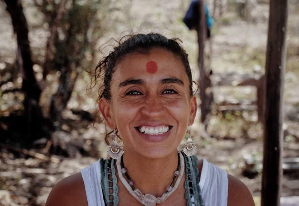 Ximena Morales, co-founder of Casa del Sol, smiling outdoors, spiritual seeker from Peru, known for her connection with nature in the Sacred Valley of Vilcabamba and her role as a mother and visionary.